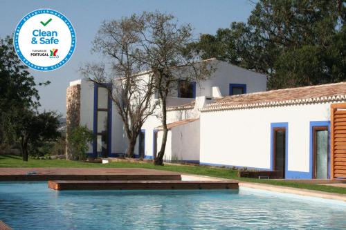 a house with a swimming pool in front of a building at Quinta Do Mel in Albufeira