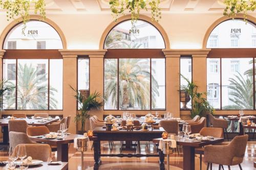 a dining room with tables and chairs and windows at Iberostar Heritage Grand Mencey in Santa Cruz de Tenerife