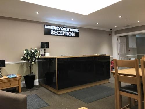 a reception desk in a room with a sign on the wall at The Waverley Guest House in Inverness