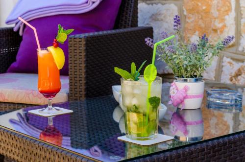 a glass table with two cocktails and flowers on it at Apartment Veronika in Dubrovnik