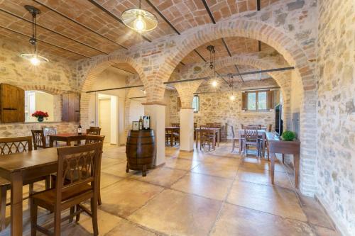 Habitación grande con pared de piedra, mesa y sillas. en Lagolivo, en Passignano sul Trasimeno