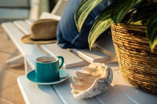 une tasse de café et une coquille sur une table dans l'établissement Migrator Intertidal Homestay, à Baisha