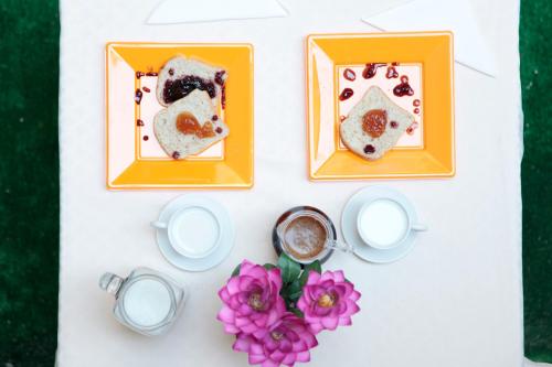 uma mesa com pratos de comida, café e flores em HOTEL Poma em Milão