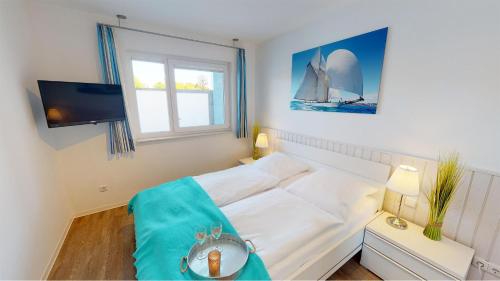 ペルツァーハケンにあるVilla Meeresrauschen Meerblick 2aの小さなベッドルーム(白いベッド1台、テレビ付)