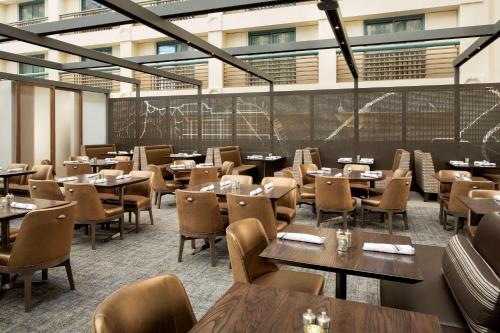 a restaurant with tables and chairs in a building at Hyatt Regency San Francisco Airport in Burlingame