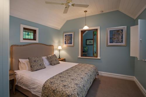 a bedroom with a bed and a ceiling fan at Oak Tree Lodge in Rhyll