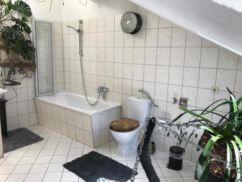 a bathroom with a toilet and a bath tub at Stadtdschungel FeWo mit Balkon in Cottbus