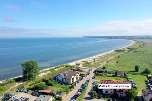 une vue aérienne sur une plage avec des voitures garées dans l'établissement Willa Bursztynowa, à Rewa
