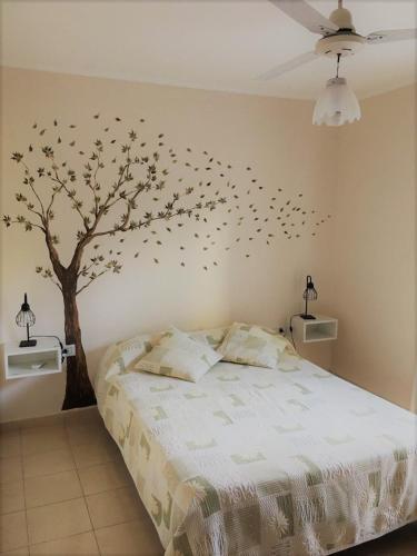 a bedroom with a tree with birds on the wall at CÓMODO DEPARTAMENTO EN ZONA CÉNTRICA in Rafaela