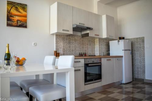 a kitchen with a white table and white appliances at Galeb in Veli Iž