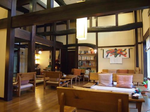 una sala de estar con sofás, mesas y sillas en Oyado Koto No Yume, en Takayama
