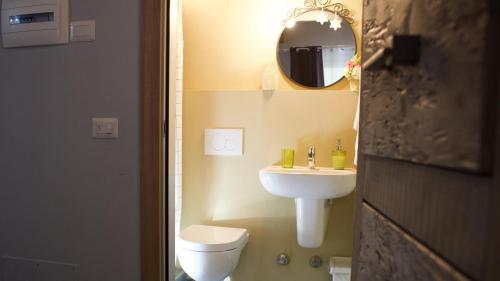 a bathroom with a sink and a toilet and a mirror at La Casa Sul Sasso in Dervio