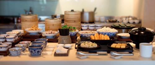 ein Buffet mit Schüsseln voller Essen auf einem Tisch in der Unterkunft Park Hyatt Ningbo Resort & Spa in Ningbo