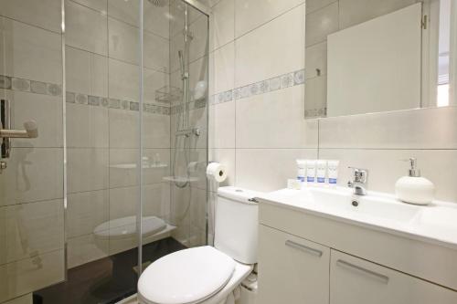 a bathroom with a toilet and a sink and a shower at Callao One in Madrid