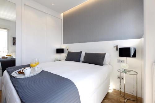 een slaapkamer met een groot wit bed en een dienblad met eten erop. bij Latina Plaza in Madrid