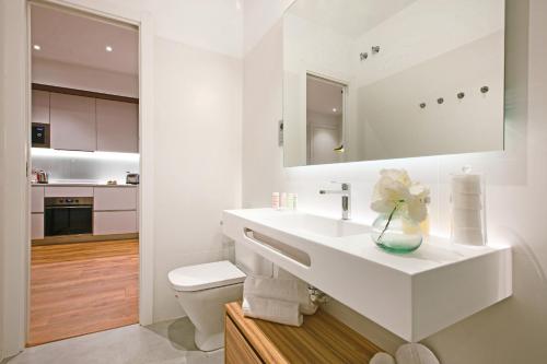 a white bathroom with a sink and a toilet at Paloma by Madflats Collection in Madrid