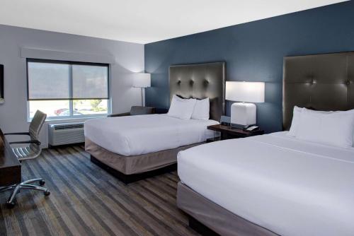 a hotel room with two beds and a desk at Hyatt House Raleigh Durham Airport in Morrisville