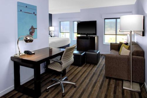 a hotel room with a desk and a bed at Hyatt House Raleigh Durham Airport in Morrisville