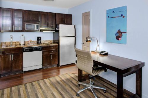 a kitchen with a desk and a refrigerator at Hyatt House Raleigh Durham Airport in Morrisville