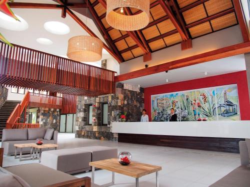 a lobby with couches and a bar in a building at Crystals Beach Resort Belle Mare, a member of Radisson Individuals in Belle Mare