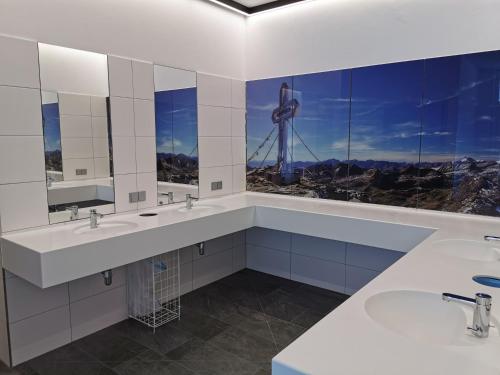 a bathroom with two sinks and a view of a windmill at Camping HOCHoben in Mallnitz