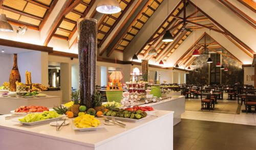 a buffet line with fruits and vegetables on display in a restaurant at Crystals Beach Resort Belle Mare, a member of Radisson Individuals in Belle Mare