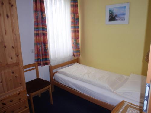 a small bedroom with a bed and a window at Pension ALPENHAUS in Vorderstoder