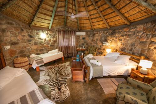 a room with two beds and a zebra in it at Shumba Safaris Bush Camp in Hoedspruit