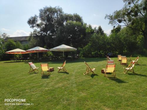 a group of lawn chairs and umbrellas in a yard at Hotel Marina in Nielisz
