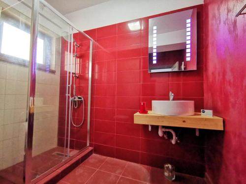 ein rotes Badezimmer mit Waschbecken und Dusche in der Unterkunft Violet Apartment-Brilliant Apartments in Constanţa