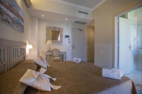 a bedroom with a large bed with bows at Hotel Hermitage in Galatina