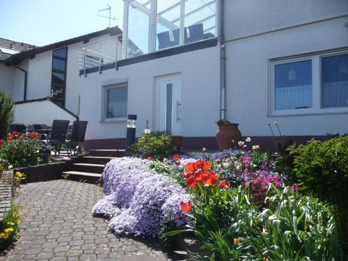 a garden in front of a house with flowers at Ferienwohnung chez nous in Erbach im Odenwald