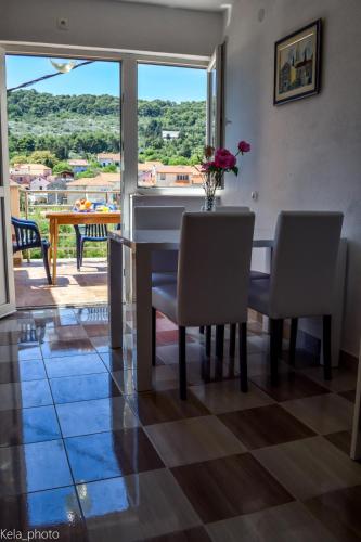a dining room with a table and chairs and a window at Galeb 2 in Veli Iž