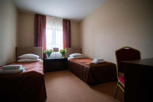 a hotel room with two beds and a window at Hotel Marina in Nielisz