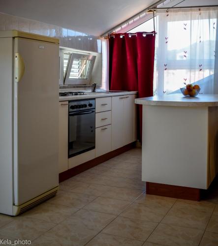 a kitchen with a white refrigerator and a stove at Galeb 3 in Veli Iž