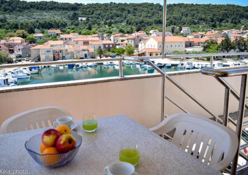 a bowl of fruit on a table with a view of a harbor at Galeb 3 in Veli Iž