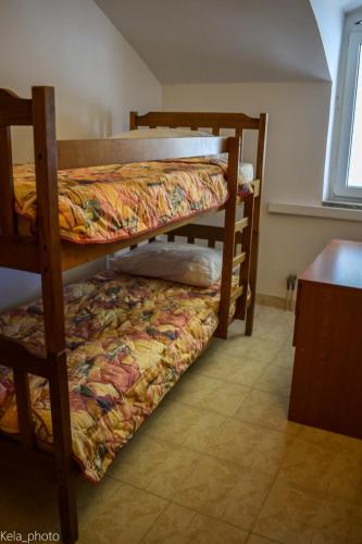 two bunk beds in a room with a bed at Galeb 3 in Veli Iž