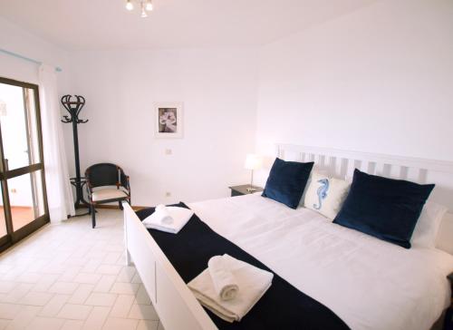 a bedroom with a large bed with blue and white pillows at T3 Holiday Cottage near the beach | B111 in Porches