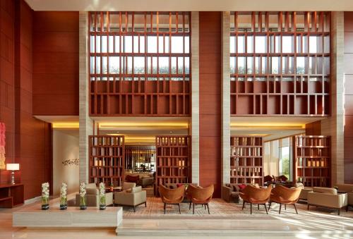 a library with chairs and tables and large windows at Hyatt Regency Chandigarh in Chandīgarh