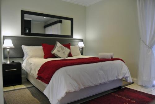 una camera da letto con un letto con una coperta rossa e uno specchio di Nations Lodge a Lynchfield