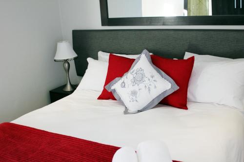 a bedroom with a white bed with red pillows at Nations Lodge in Lynchfield