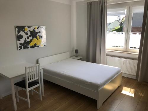 ein Schlafzimmer mit einem Bett, einem Stuhl und einem Fenster in der Unterkunft Haus Kyllblick in Birresborn