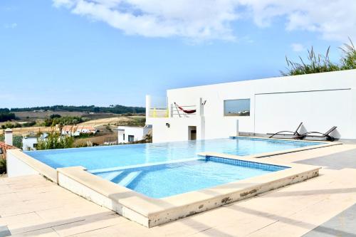 a swimming pool on the roof of a house at The Maverick Surfvillas in Lourinhã