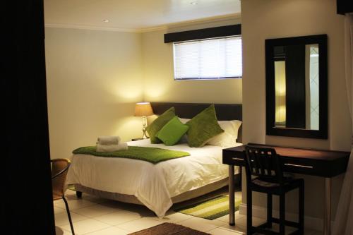 a bedroom with a bed with a desk and a mirror at Nations Lodge in Lynchfield