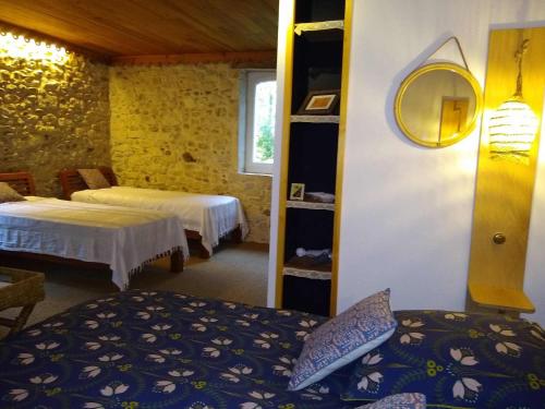 a hotel room with two beds and a mirror at Maison Basta in Orthevielle