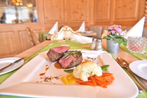 a plate of food with meat and vegetables on a table at Hotel Hirschen in Schluchsee