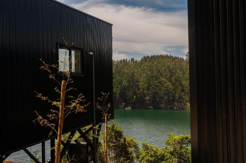 a view of a lake from a black building at Pura Lodge in Concepción