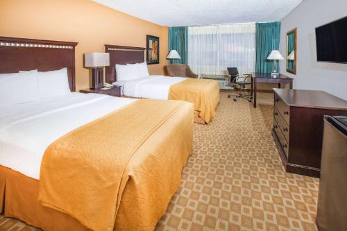 a hotel room with two beds and a desk at Days Inn by Wyndham Sherman in Sherman