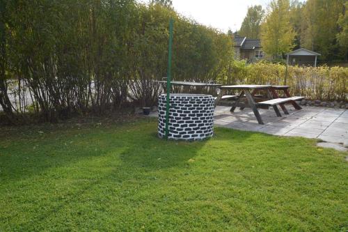 a picnic table and a bench in the grass at Motel E4 Kolmården Apartments And Cottages in Kolmården