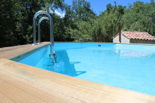 a swimming pool with blue water and metal faucets at LE RESPECHAT in Saint-Christol-lès-Alès